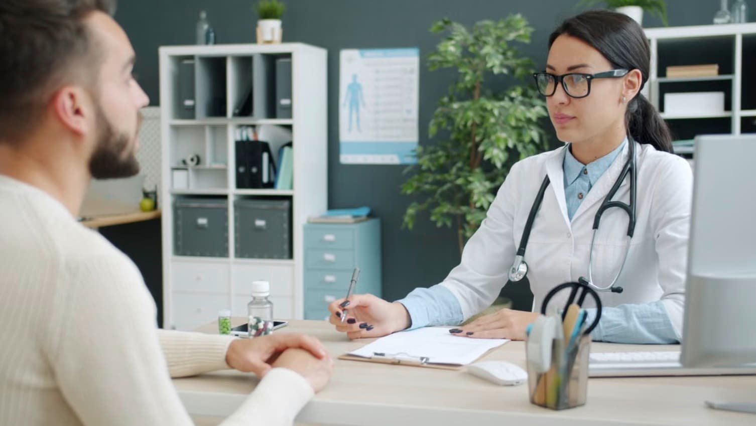 A clinician listening to a patient across her desk